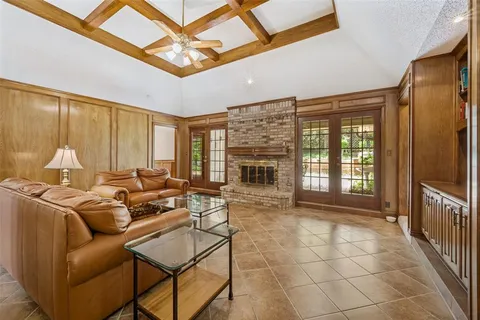 a living room with furniture a fireplace and a ceiling fan