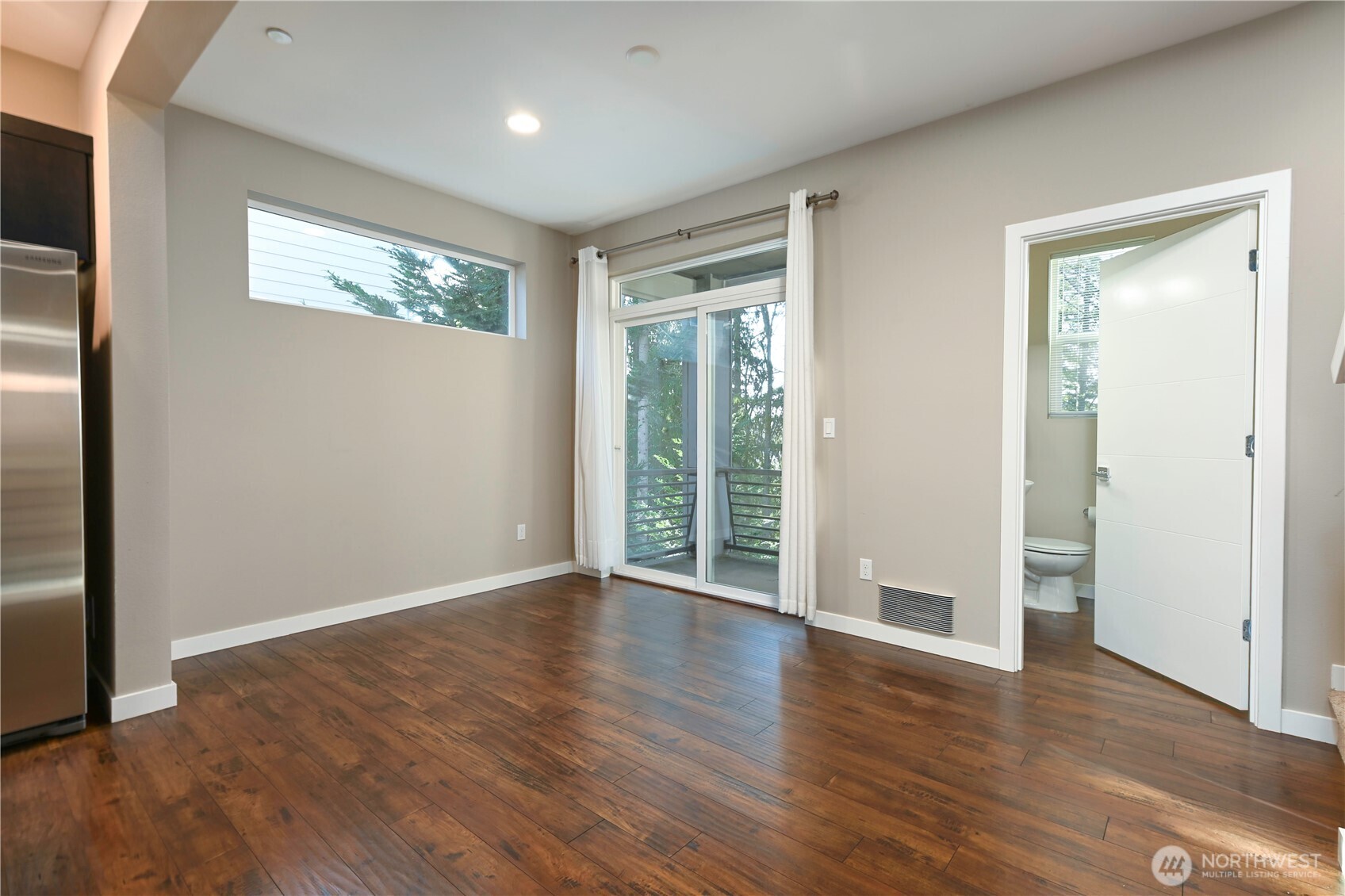 13724 Ash Way, Unit C1 Everett, WA 98204 - Photo 16 of 36 a view of an empty room with wooden floor and a window