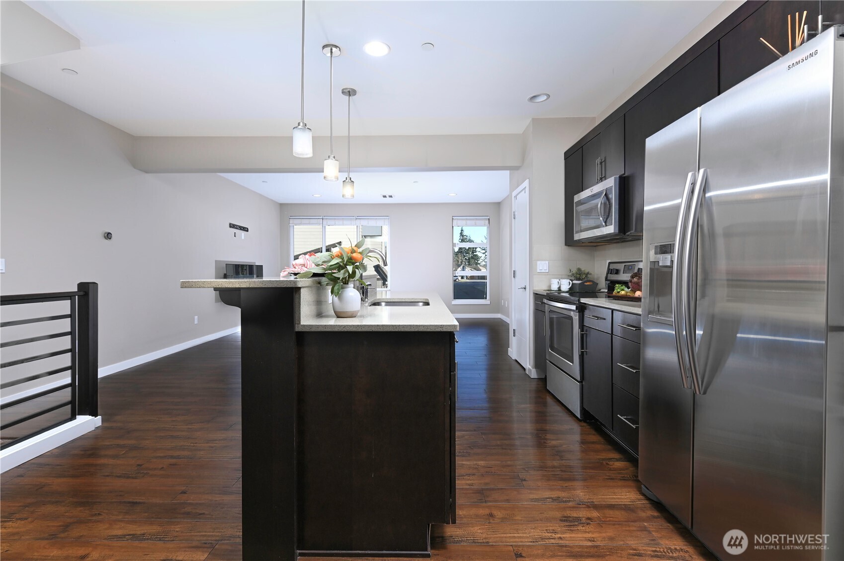 13724 Ash Way, Unit C1 Everett, WA 98204 - Photo 8 of 36 a kitchen with stainless steel appliances granite countertop a refrigerator a sink dishwasher a stove and a dining table with wooden floor
