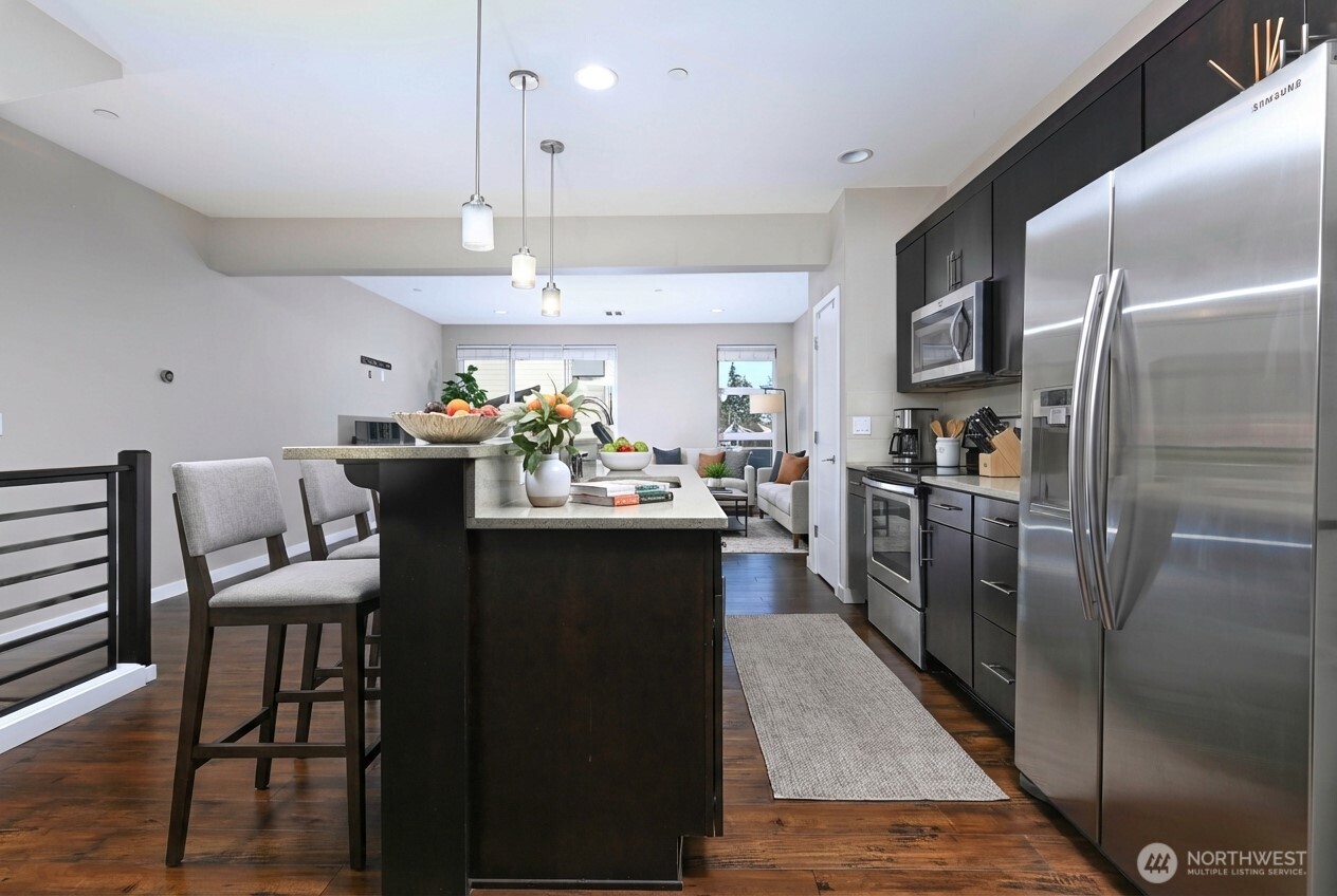 13724 Ash Way, Unit C1 Everett, WA 98204 - Photo 9 of 36 a kitchen with a dining table chairs stainless steel appliances and cabinets