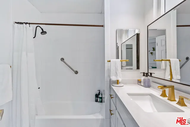 a bathroom with a tub sink and mirror