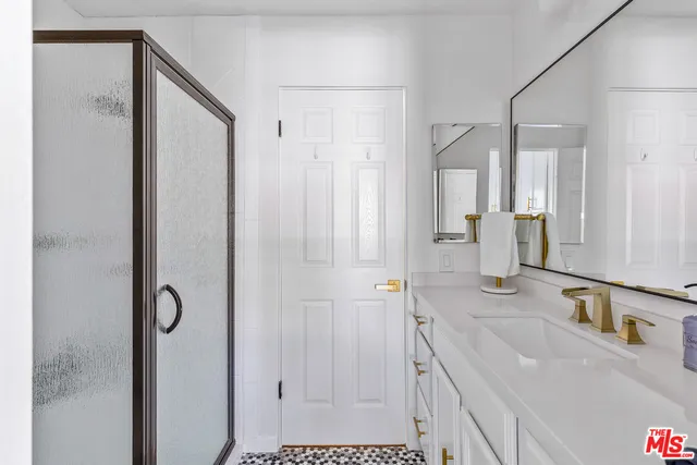 a bathroom with a shower sink and mirror