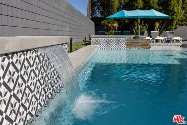 a view of a patio with table and chairs under an umbrella