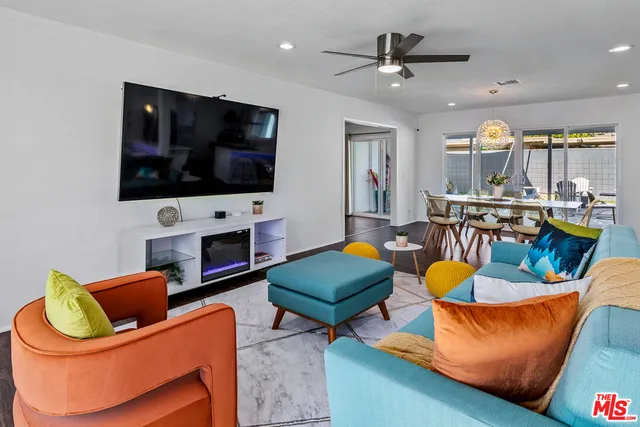 a living room with furniture a flat screen tv and kitchen view