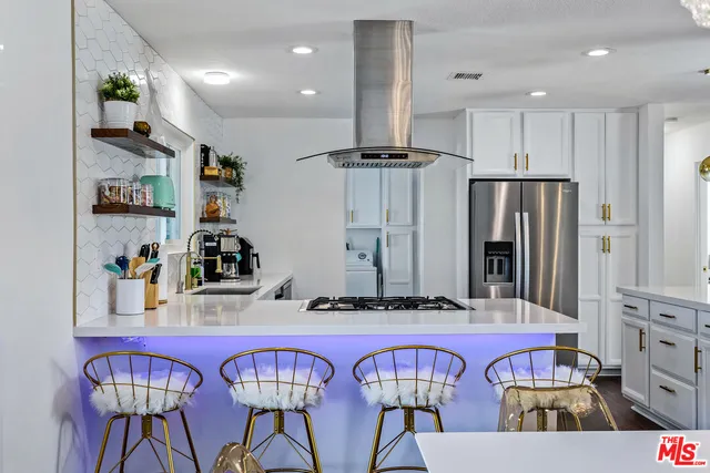 a kitchen with stainless steel appliances kitchen island granite countertop a refrigerator and microwave