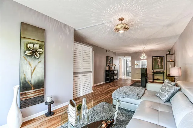 a bedroom with a large bed a flat tv screen and a chandelier