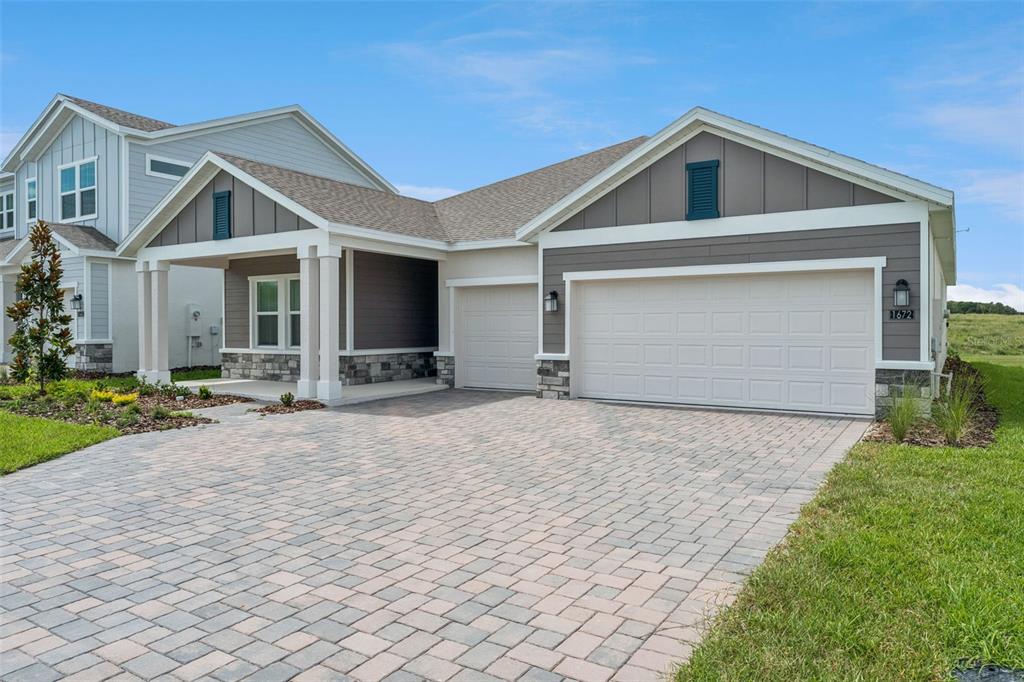 1672 Rider Rain Lane Apopka, FL 32703 - Photo 3 of 35 a front view of a house with a yard and garage