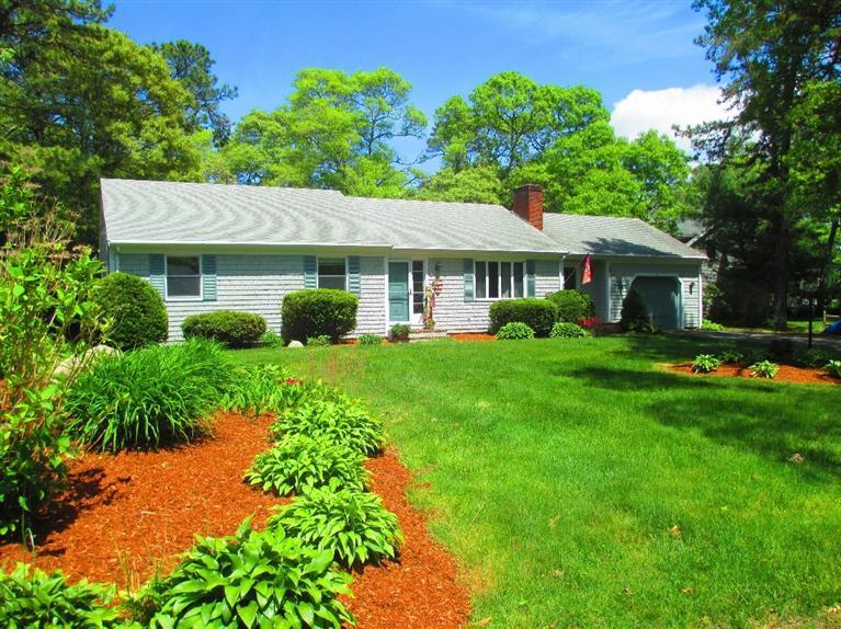 52 Thread Needle Lane Centerville, MA 02632 - Photo 2 of 32 a front view of a house with garden and trees