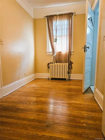 an empty room with wooden floor and closet