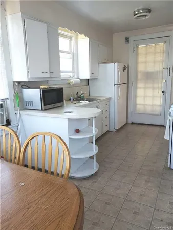 a kitchen with stainless steel appliances granite countertop a stove a sink a refrigerator and white cabinets