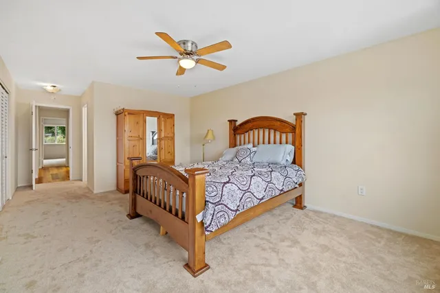 a bed sitting in a spacious bedroom next to a window