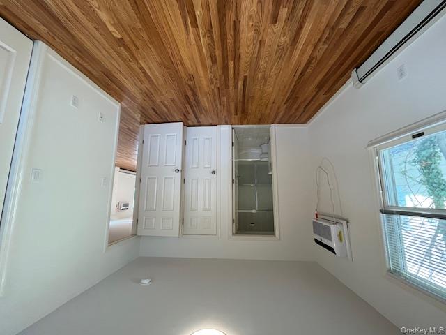46 Firwood Road, Unit 1 Port Washington, NY 11050 - Photo 12 of 16 Unfurnished bedroom featuring a baseboard heating unit, wood finished floors, ensuite bathroom, and a wall mounted AC