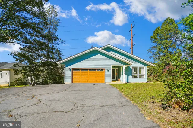 a view of a house with a yard and large tree