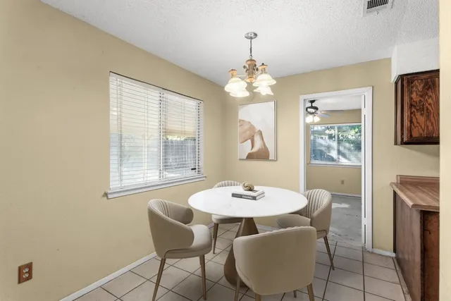 a view of a dining room with furniture a chandelier and window