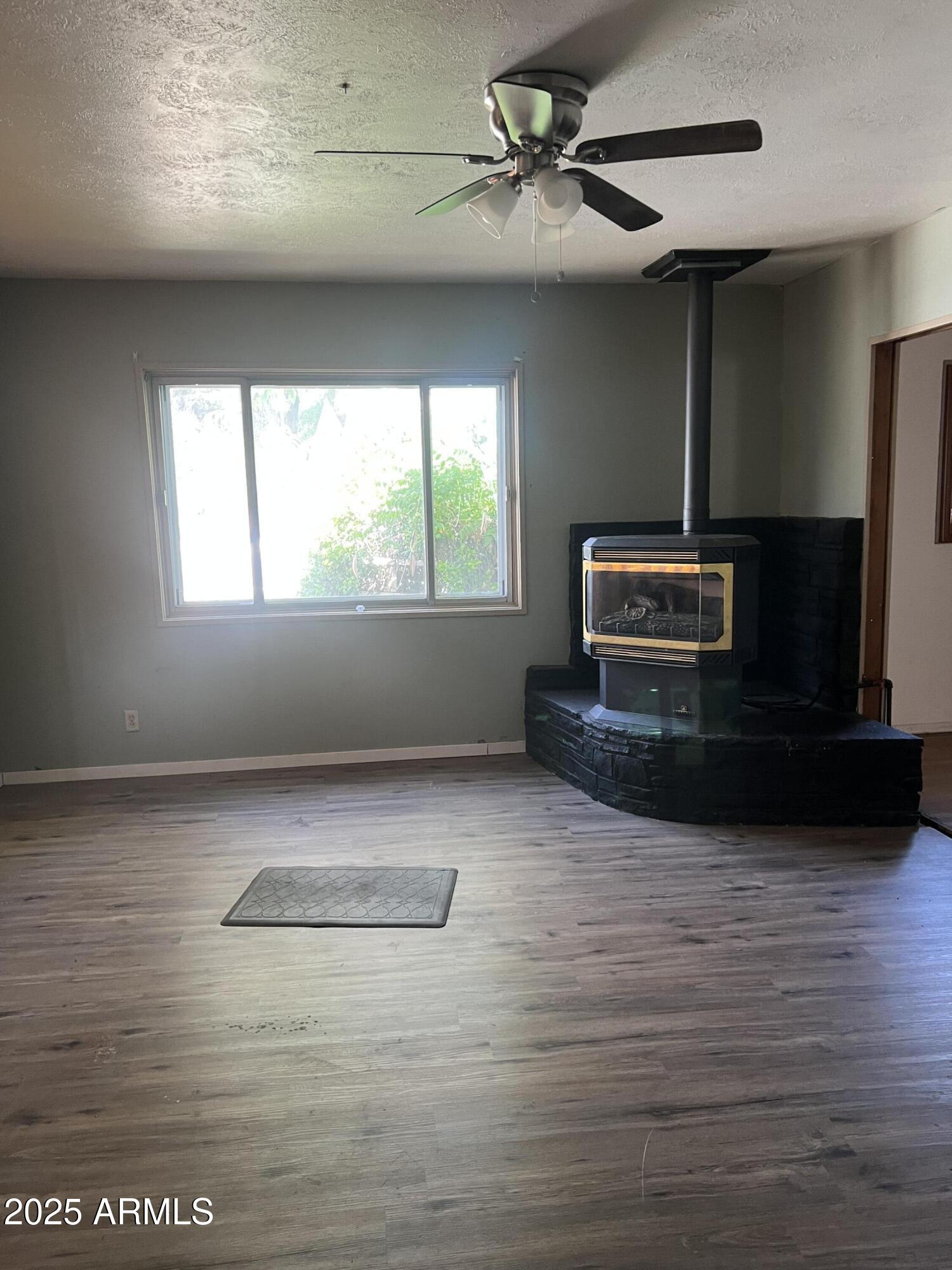 566 Carico Street Globe, AZ 85501 - Photo 13 of 22 a living room with hard wood floors and a ceiling fan