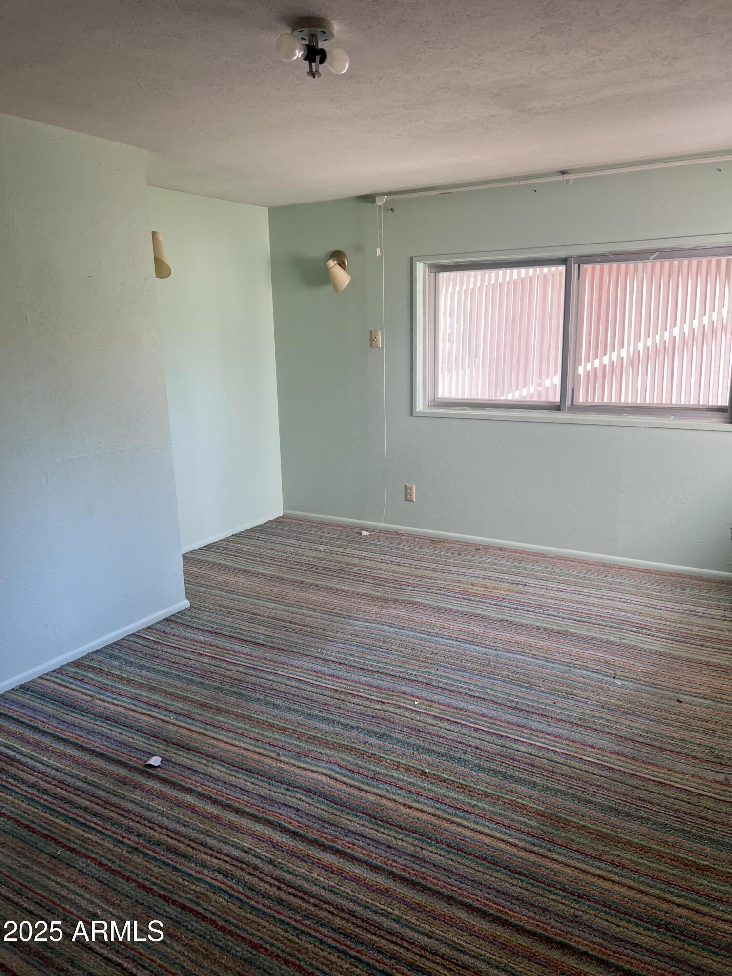 566 Carico Street Globe, AZ 85501 - Photo 19 of 22 a view of an empty room with wooden floor and a window