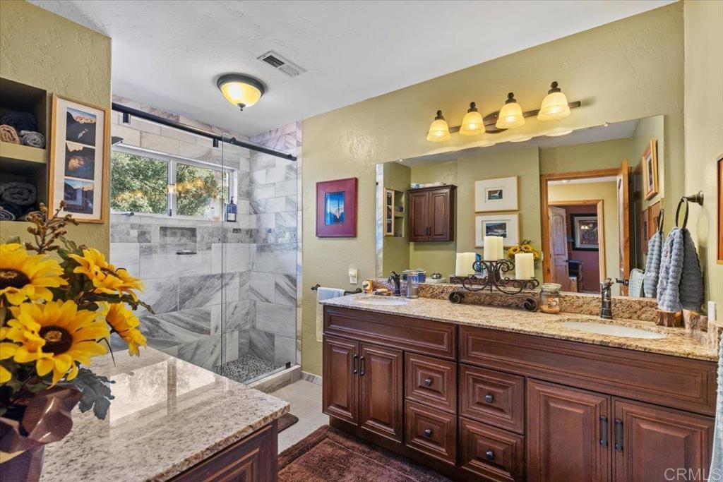10499 Highway 79 Descanso, CA 91916 - Photo 32 of 75 a bathroom with a granite countertop sink mirror and shower