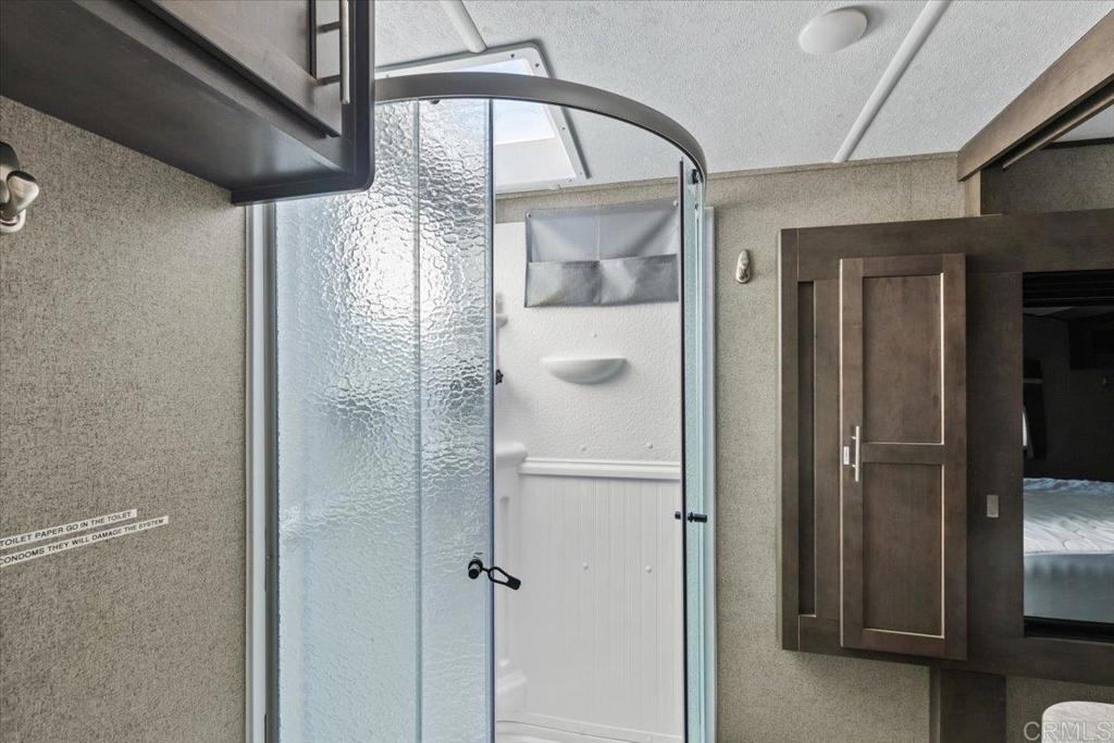 10499 Highway 79 Descanso, CA 91916 - Photo 46 of 75 a bathroom with a glass shower door and mirror