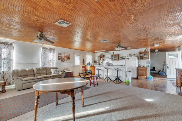 a living room with furniture and a dining table with rug
