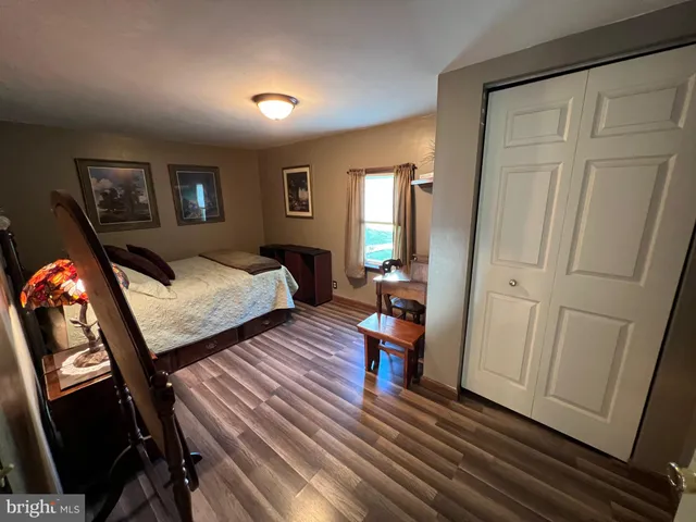a bedroom with bed and wooden floor