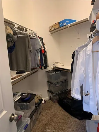 a view of walk in closet with clothes and shoes