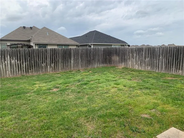 a view of a backyard with wooden fence
