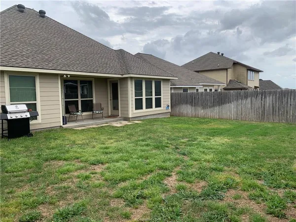 a view of a house with a yard and sitting area