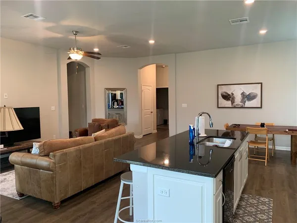 a living room with furniture a dining table and a flat screen tv