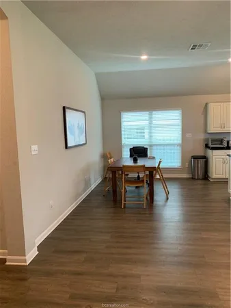 a dining room with furniture and wooden floor
