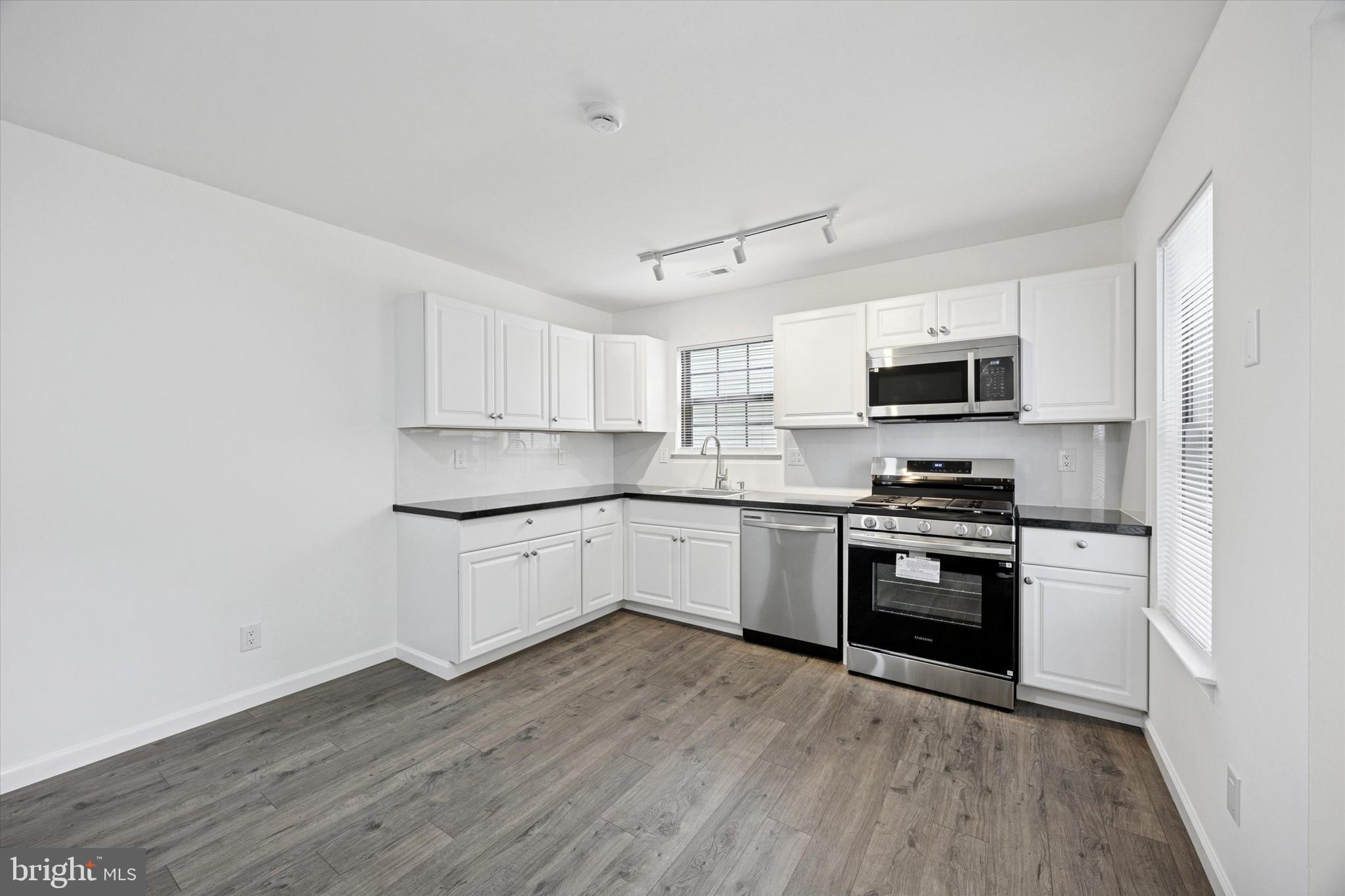 532 Cormorant Drive Voorhees, NJ 08043 - Photo 11 of 25 a kitchen with stainless steel appliances granite countertop a stove top oven a sink dishwasher and a refrigerator with wooden floor
