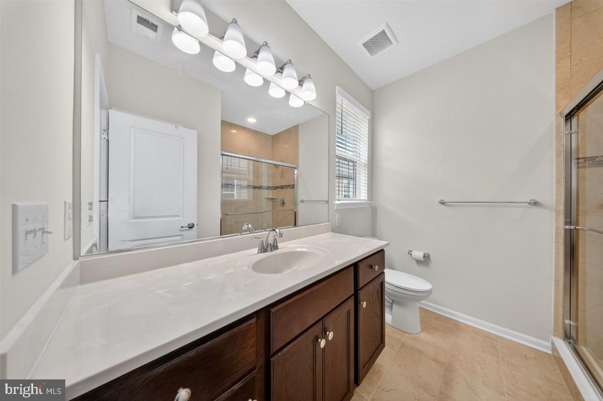 1426 Whispering Woods Road Middletown, DE 19709 - Photo 20 of 37 a bathroom with a sink a toilet a light fixture and a mirror