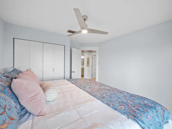 a bed room with a bed and a ceiling fan