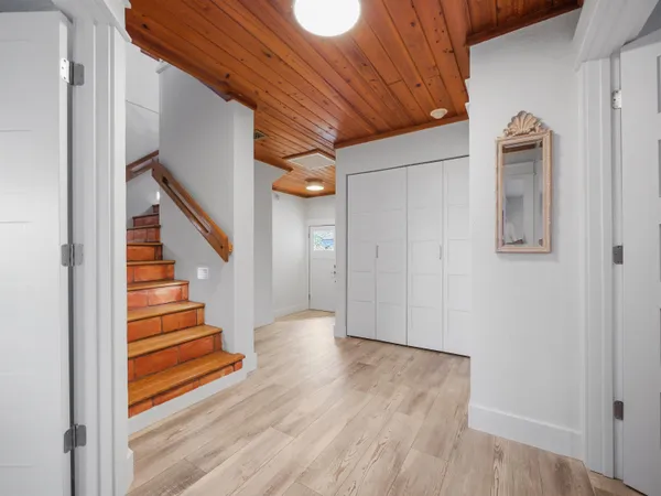 a view of a hallway with wooden floor and staircase