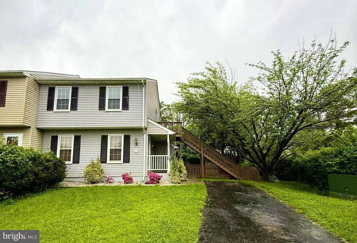 a front view of a house with a yard and trees