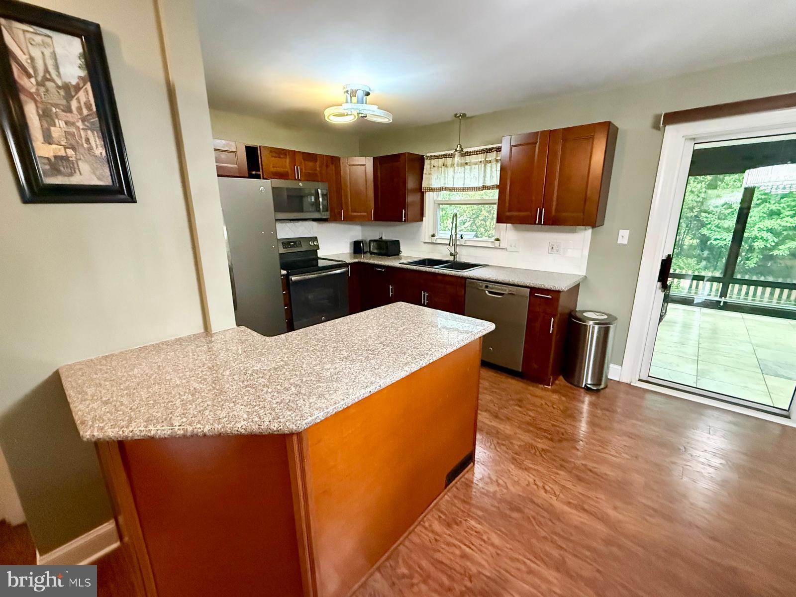 1498 Key Parkway Frederick, MD 21702 - Photo 5 of 28 a kitchen with stainless steel appliances granite countertop a refrigerator a stove top oven a sink dishwasher and wooden cabinets with wooden floor