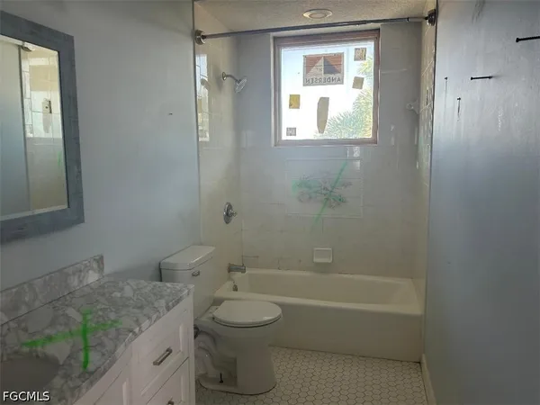 a bathroom with a granite countertop toilet a sink and bathtub