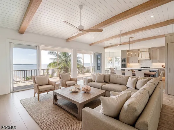 a living room with furniture a rug potted plant and a large window