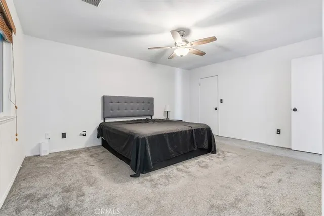 a bedroom with a bed and a ceiling fan