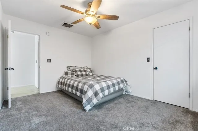 a bedroom with a bed and a ceiling fan