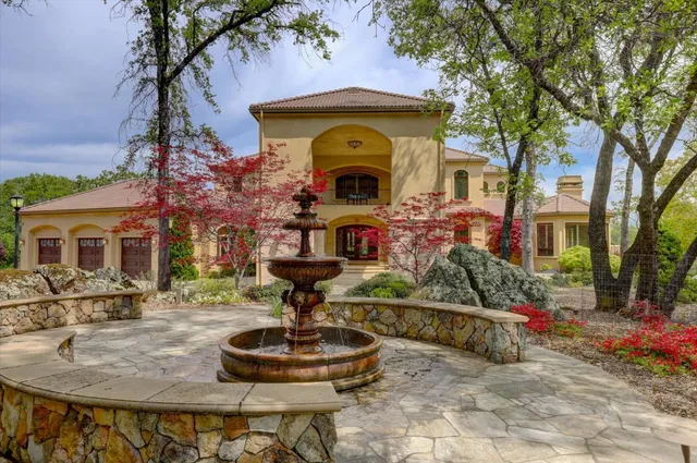a front view of a house with fountain table and chairs