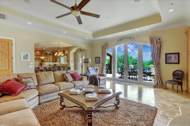 a room with lots of tables a chandelier and pool view