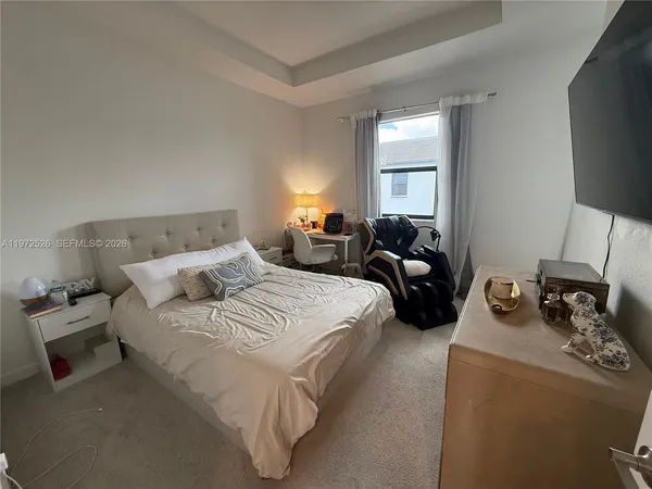 a hotel room with two flat screen tv and a bed