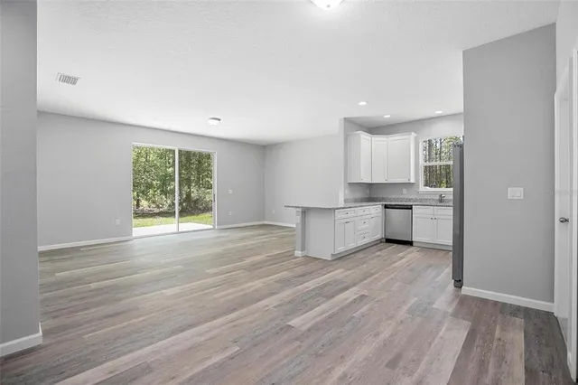 a kitchen with granite countertop white cabinets and stainless steel appliances