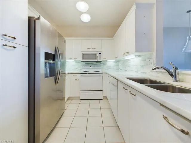 a kitchen with a sink a refrigerator and cabinets