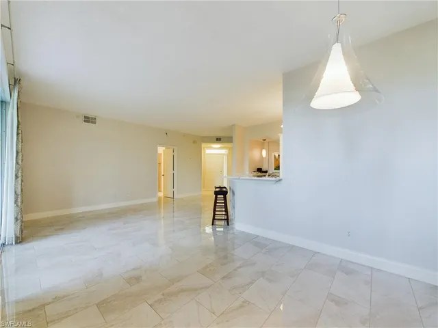 an empty room with windows and cabinet