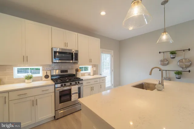 a kitchen with kitchen island a sink stainless steel appliances and cabinets