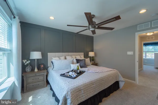 a bedroom with a bed and a ceiling fan