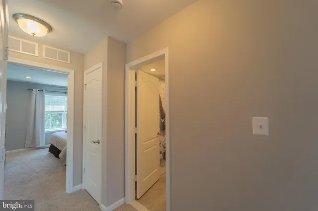 a view of a hallway with a livingroom and a bathroom
