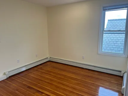 a view of a room with wooden floor and window