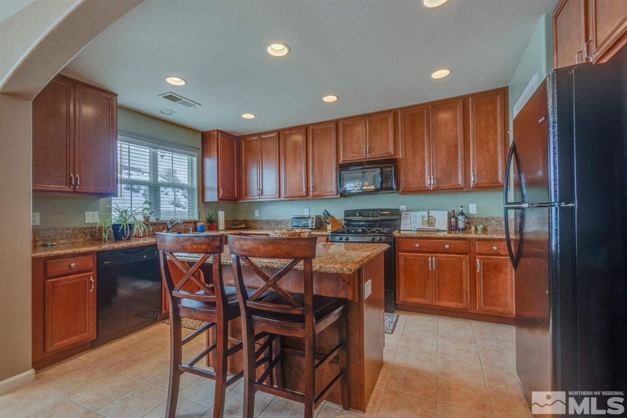7660 Stone Bluff Way Reno, NV 89523 - Photo 6 of 22 a kitchen with stainless steel appliances granite countertop wooden cabinets a stove top oven a sink and dishwasher